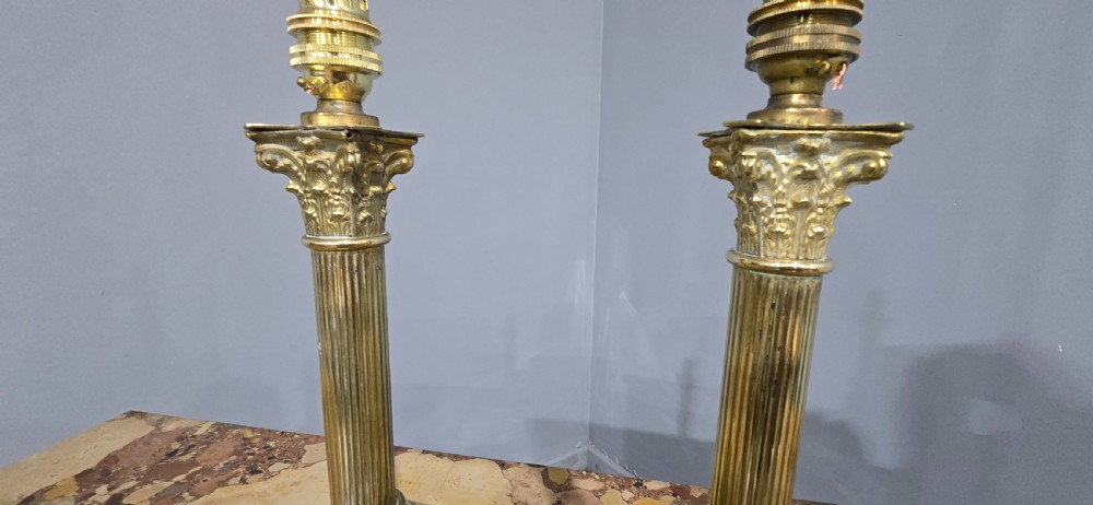 A pair of antique cast brass table lamps styled as classical fluted Corinthian columns with stepped bases. View V