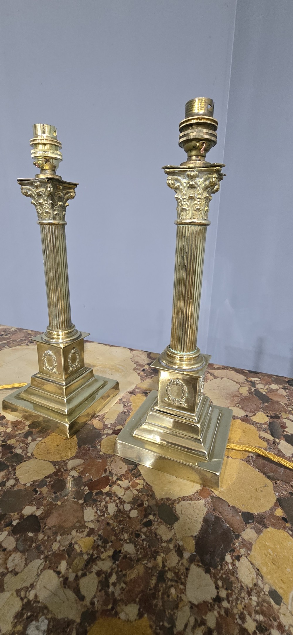 A pair of antique cast brass table lamps styled as classical fluted Corinthian columns with stepped bases. View VI