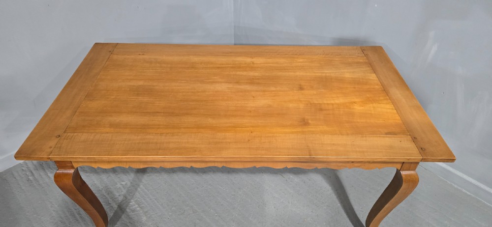 A French provincial solid cherry dining table featuring cabriole legs and a scalloped apron. View II