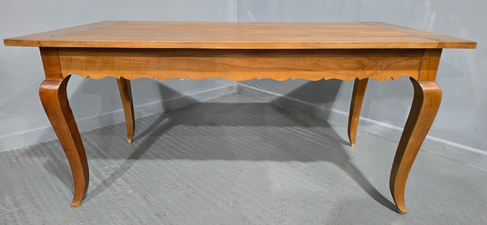 A French provincial solid cherry dining table featuring cabriole legs and a scalloped apron. View III
