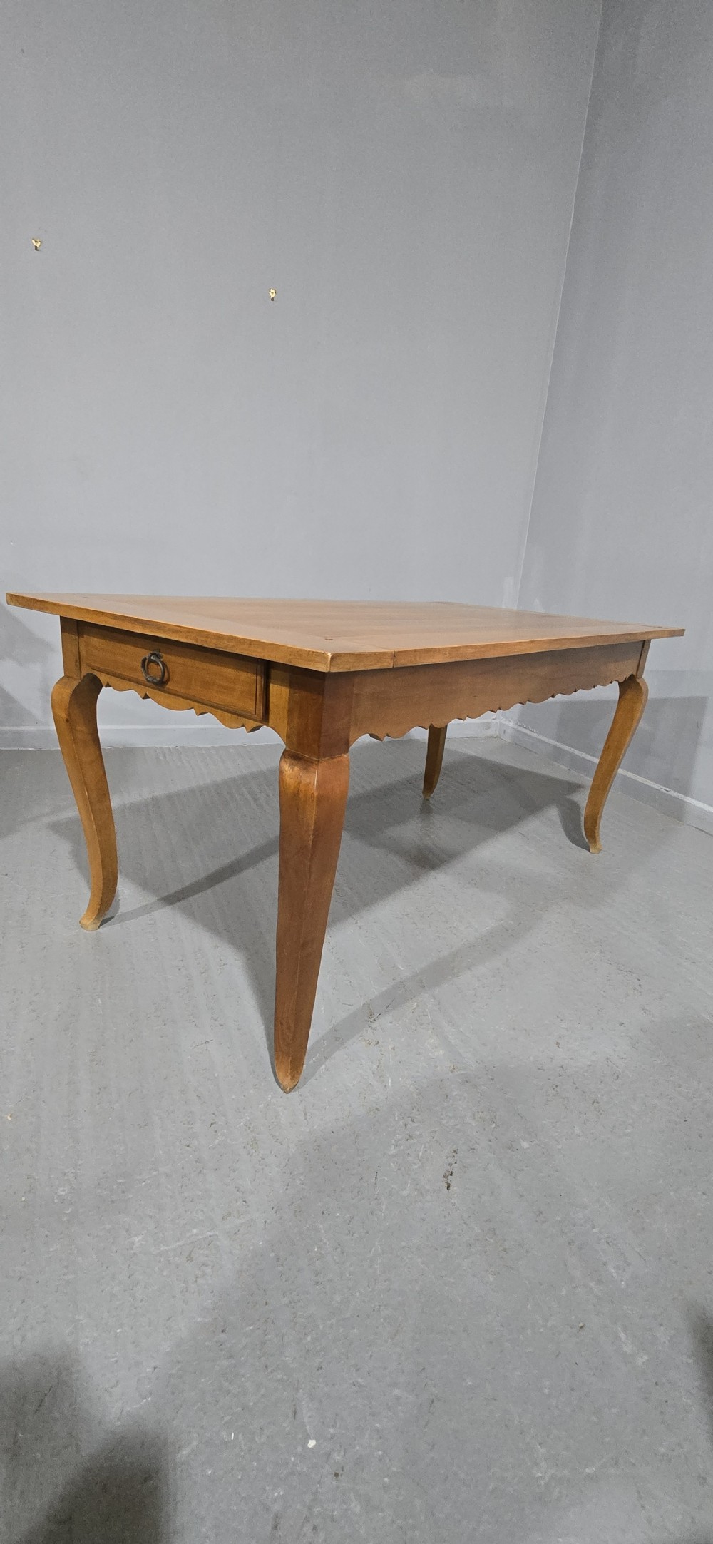 A French provincial solid cherry dining table featuring cabriole legs and a scalloped apron. View IX
