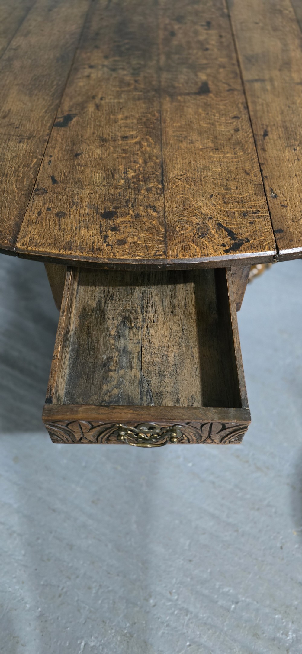 An 18th-century oak drop-leaf dining table featuring turned legs, lower stretchers, and a carved end frieze. View XI