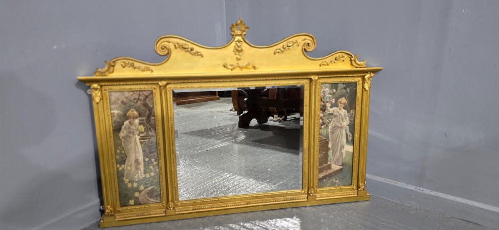 An Edwardian giltwood overmantel mirror featuring a central rectangular glass panel flanked by two vertical printed panels depicting classic female figures in garden settings. View IV
