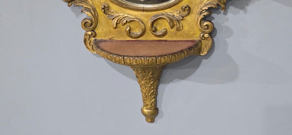 An ornate gold giltwood girandole wall mirror featuring carved Rococo scrollwork and twin integrated candle sconces. View VIII