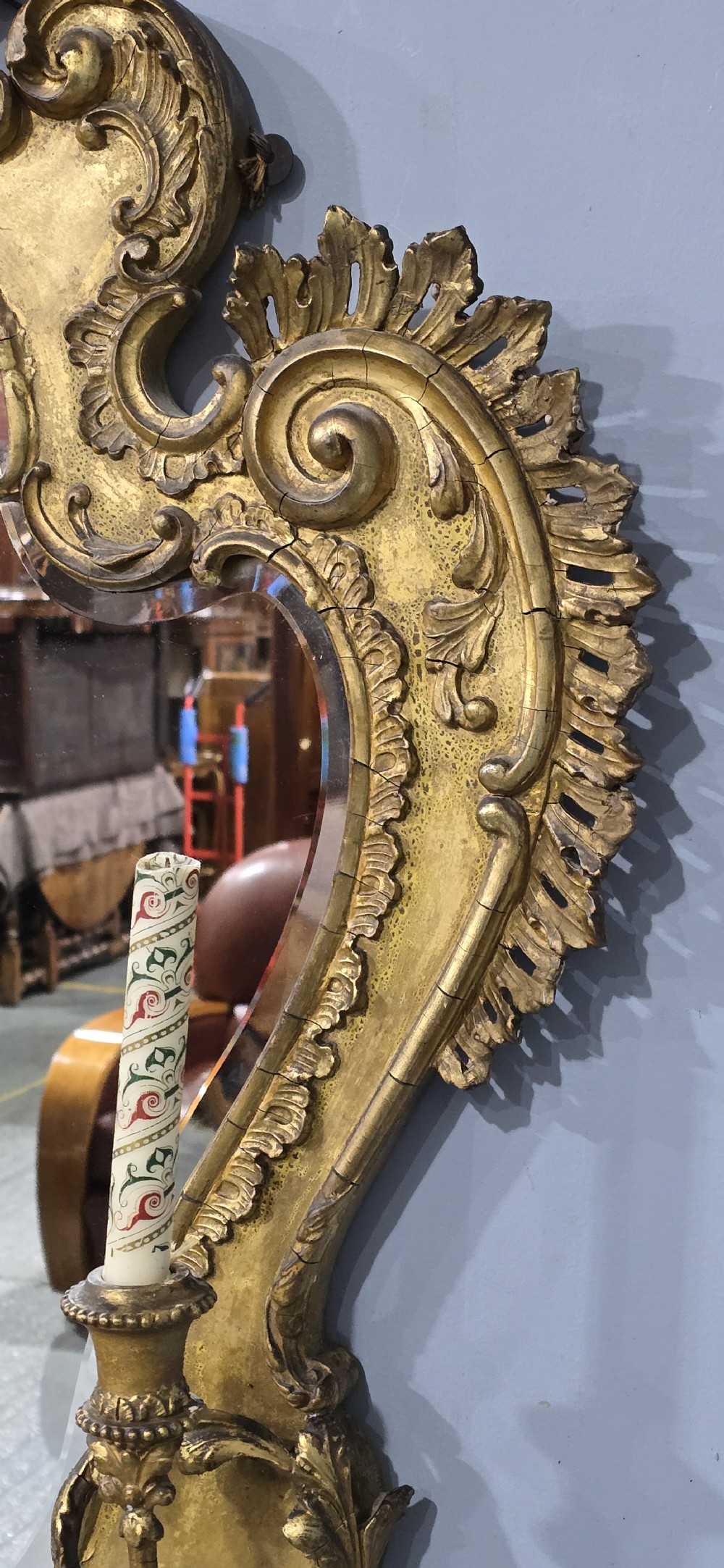 An ornate gold giltwood girandole wall mirror featuring carved Rococo scrollwork and twin integrated candle sconces. View X