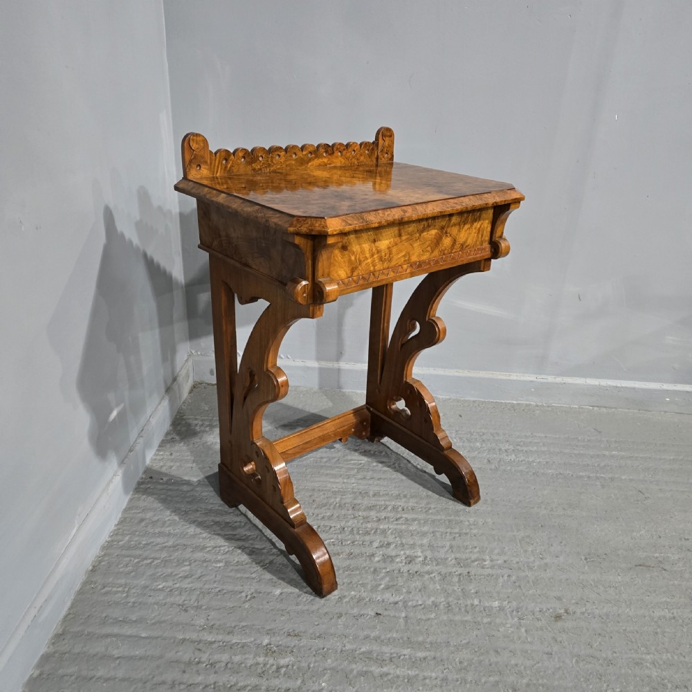 A Victorian burr walnut console table featuring a scalloped gallery back, rich burr veneer top, and carved shaped support legs connected by a central stretcher. View II
