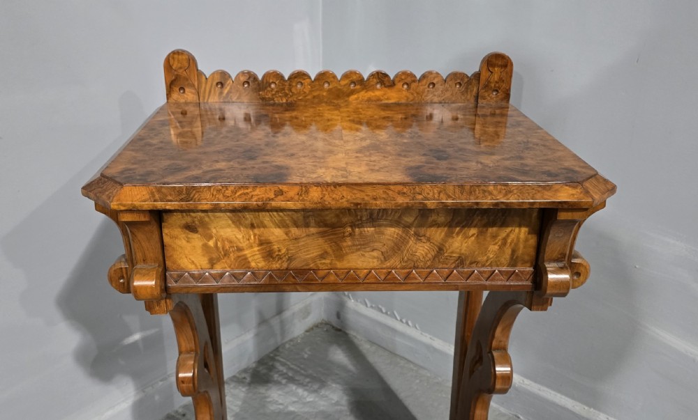 A Victorian burr walnut console table featuring a scalloped gallery back, rich burr veneer top, and carved shaped support legs connected by a central stretcher. View III
