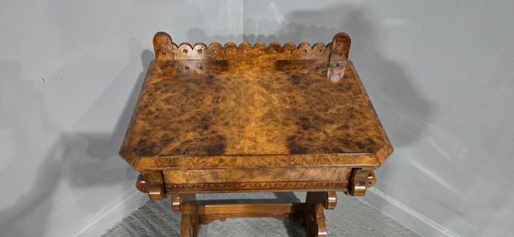 A Victorian burr walnut console table featuring a scalloped gallery back, rich burr veneer top, and carved shaped support legs connected by a central stretcher. View V