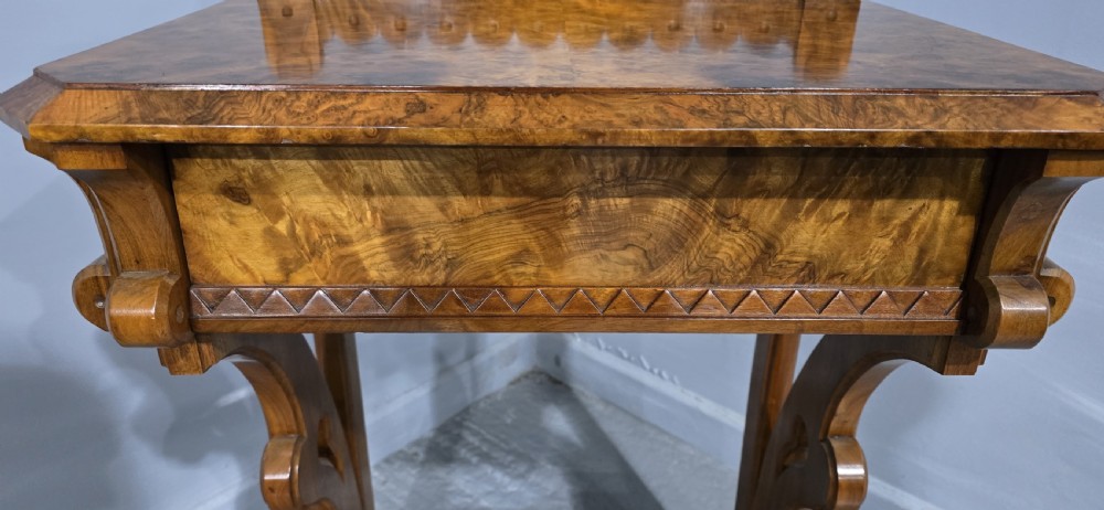 A Victorian burr walnut console table featuring a scalloped gallery back, rich burr veneer top, and carved shaped support legs connected by a central stretcher. View VII
