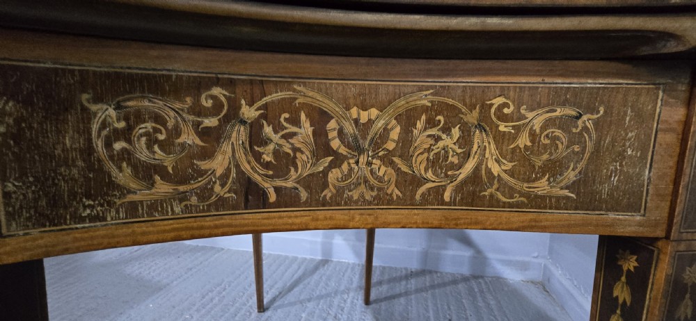 An antique mahogany card table featuring detailed marquetry inlay, a serpentine front, an ornamental urn motif, and square tapered legs. View XII