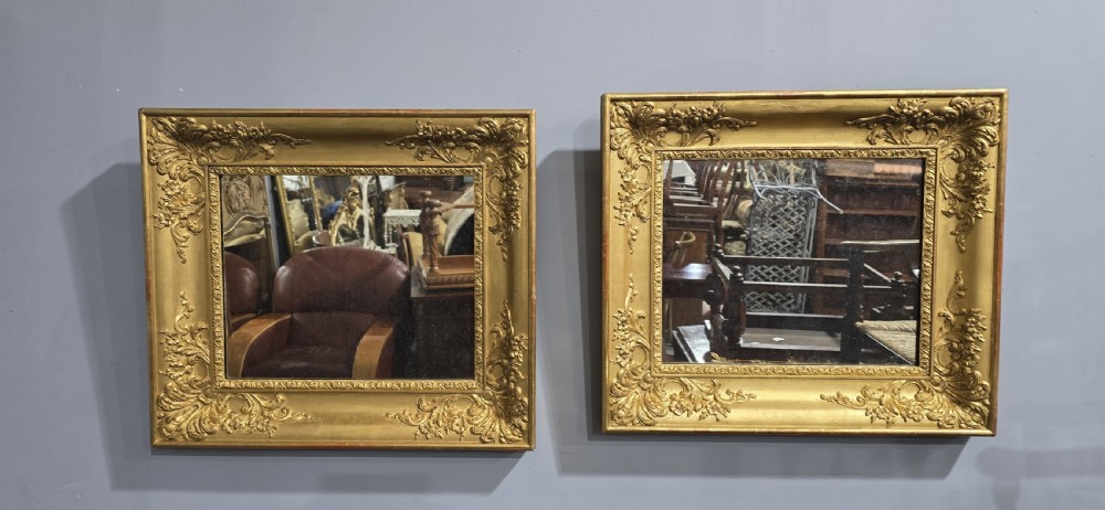 A pair of square antique early Victorian mirrors featuring ornate gold gilt frames with deeply moulded corner scrolls. View II