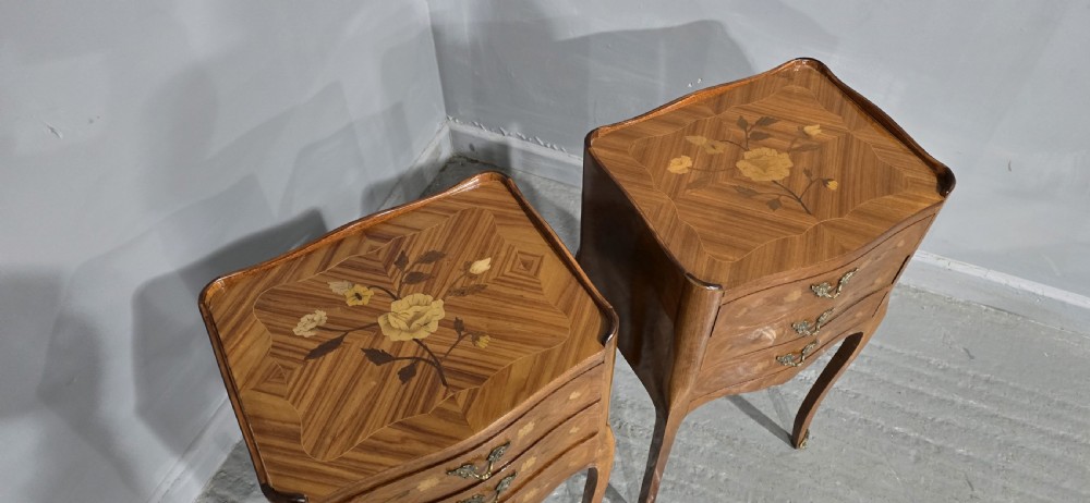 A pair of French marquetry bedside chests with three drawers, floral wood inlays, cabriole legs, and brass handles. View VII