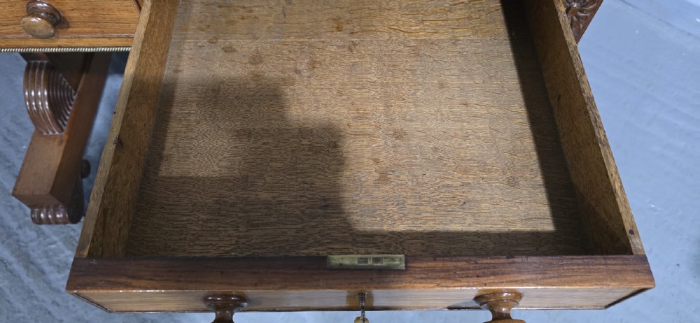 A Regency rosewood sofa table with two frieze drawers, brass line inlay, drop leaves, carved rosette corners, and reeded legs on brass castors. View XIX