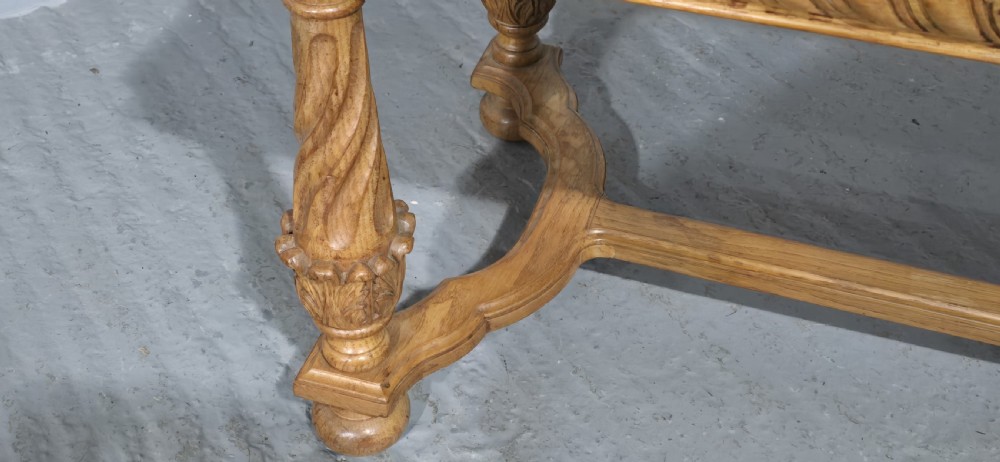 A rectangular carved light oak footboard bench featuring a gadrooned edge, turned twist legs with acanthus leaf details, and a lower connecting stretcher. View IV