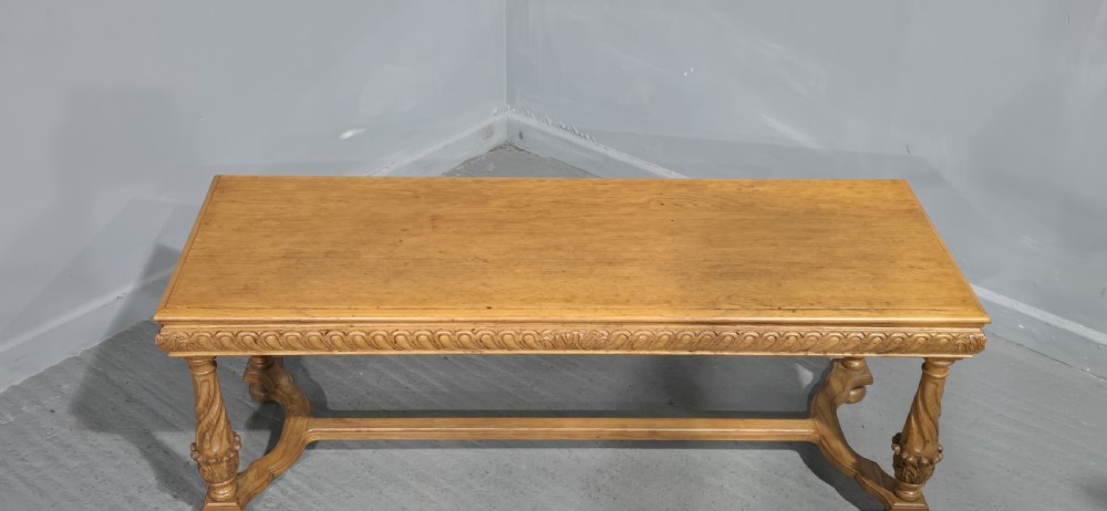 A rectangular carved light oak footboard bench featuring a gadrooned edge, turned twist legs with acanthus leaf details, and a lower connecting stretcher. View VI