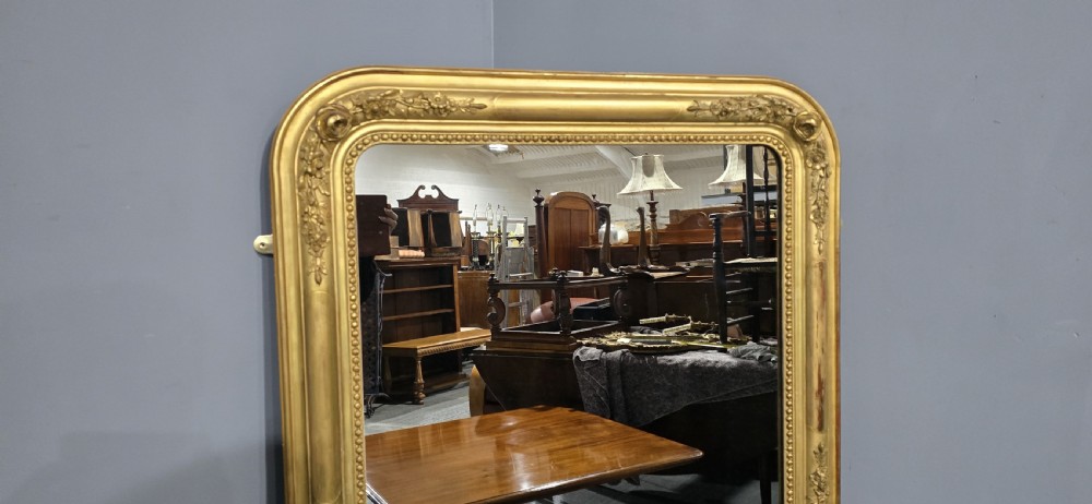 A large rectangular antique giltwood pier mirror featuring rounded top corners, beaded inner borders, and floral relief moulding along the gold frame. View III