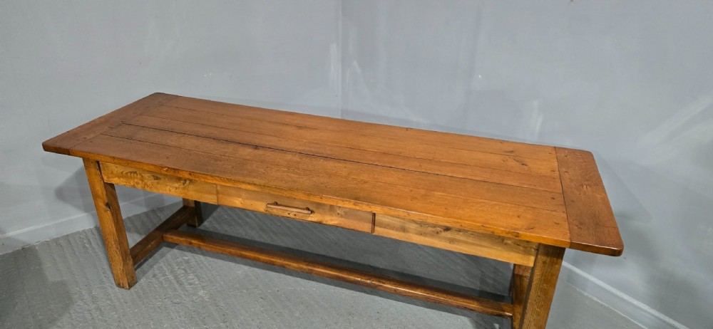 A long wooden French farmhouse refectory dining table featuring a central frieze drawer and lower stretcher bar. View III