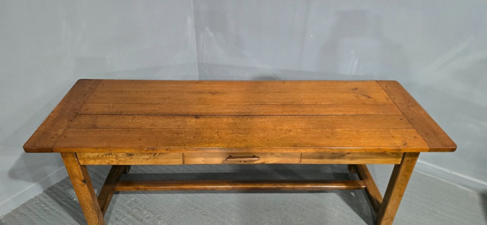 A long wooden French farmhouse refectory dining table featuring a central frieze drawer and lower stretcher bar. View VIII