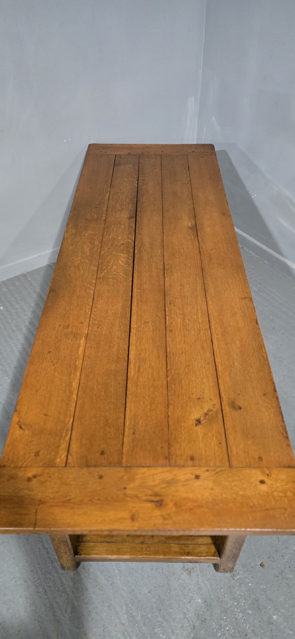 A long wooden French farmhouse refectory dining table featuring a central frieze drawer and lower stretcher bar. View XII