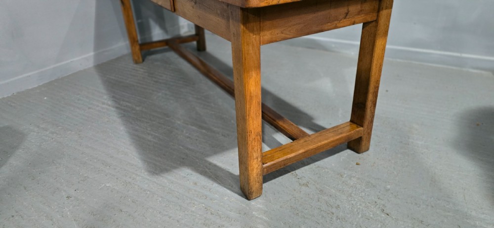 A long wooden French farmhouse refectory dining table featuring a central frieze drawer and lower stretcher bar. View XIV