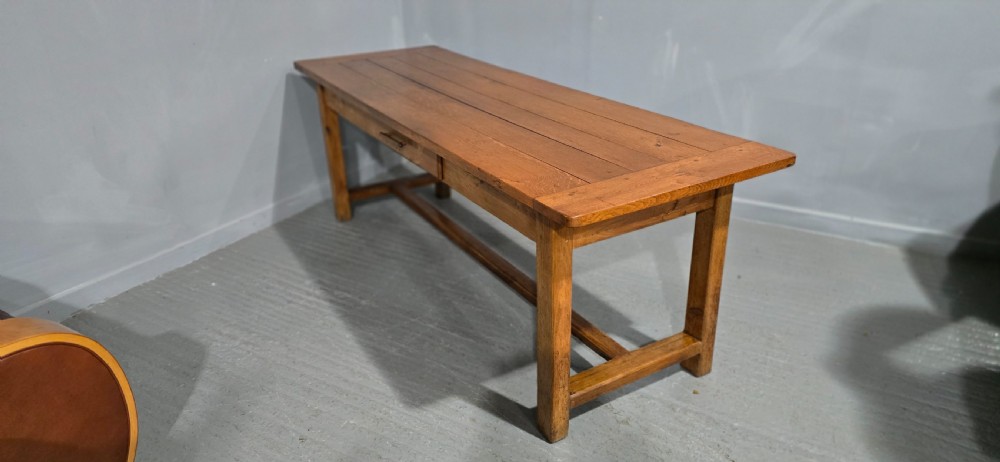 A long wooden French farmhouse refectory dining table featuring a central frieze drawer and lower stretcher bar. View XV