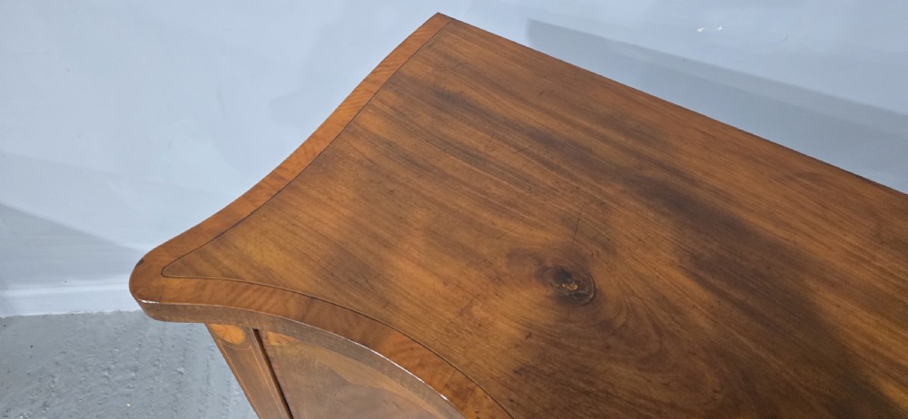 An Edwardian mahogany sideboard featuring satinwood inlay, oval fan motifs, central drawers, flanking cupboards, and slender tapered legs. View IX