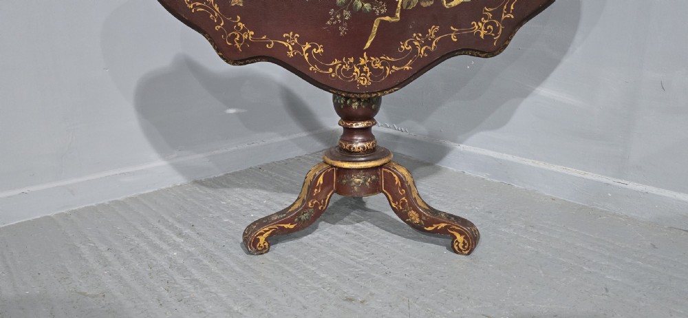 An Italian painted tilt-top side table featuring a dark burgundy ground decorated with a central hand-painted floral bouquet and gilt scrollwork borders. View II