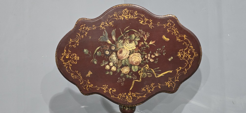 An Italian painted tilt-top side table featuring a dark burgundy ground decorated with a central hand-painted floral bouquet and gilt scrollwork borders. View III