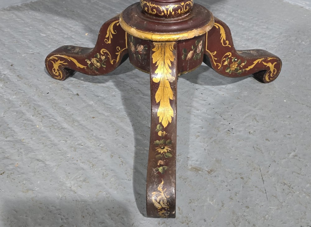 An Italian painted tilt-top side table featuring a dark burgundy ground decorated with a central hand-painted floral bouquet and gilt scrollwork borders. View IX