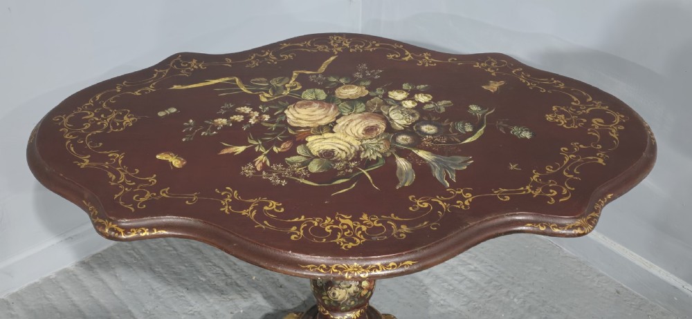 An Italian painted tilt-top side table featuring a dark burgundy ground decorated with a central hand-painted floral bouquet and gilt scrollwork borders. View XIV