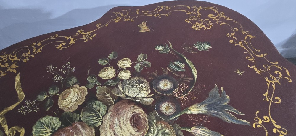 An Italian painted tilt-top side table featuring a dark burgundy ground decorated with a central hand-painted floral bouquet and gilt scrollwork borders. View XVIII