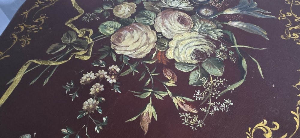 An Italian painted tilt-top side table featuring a dark burgundy ground decorated with a central hand-painted floral bouquet and gilt scrollwork borders. View XIX