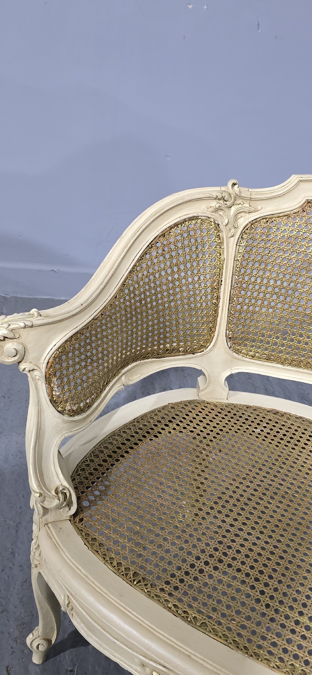 A French Louis XV style cream painted and gilded tub armchair featuring a carved wooden frame with hand-woven rattan cane back, sides, and seat on cabriole legs. View XI