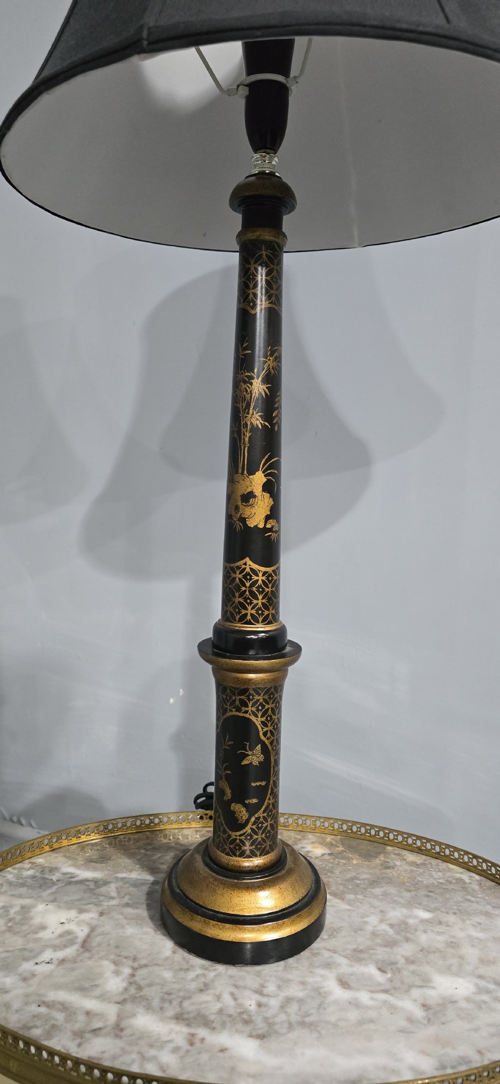 A pair of tall black lacquered table lamps featuring hand-painted gold Chinoiserie motifs and topped with black fabric shades. View VI