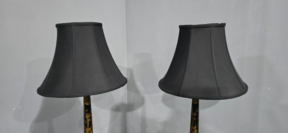 A pair of tall black lacquered table lamps featuring hand-painted gold Chinoiserie motifs and topped with black fabric shades. View VII