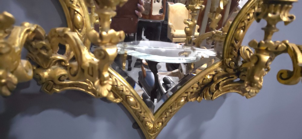 A pair of shaped giltwood girandole wall mirrors featuring ornate carved frames, integrated glass shelves, and multi-branch candle sconces. View XII