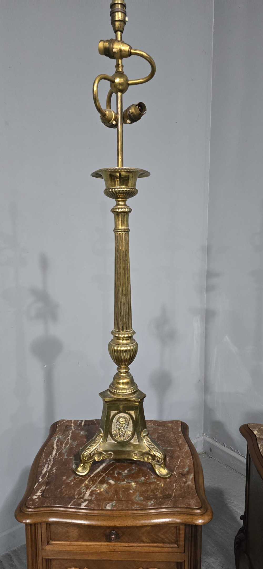 A pair of tall cast brass candlestick table lamps featuring fluted columns, relief portrait medallions on triform bases, and multi-bulb electrical fittings at the top. View II
