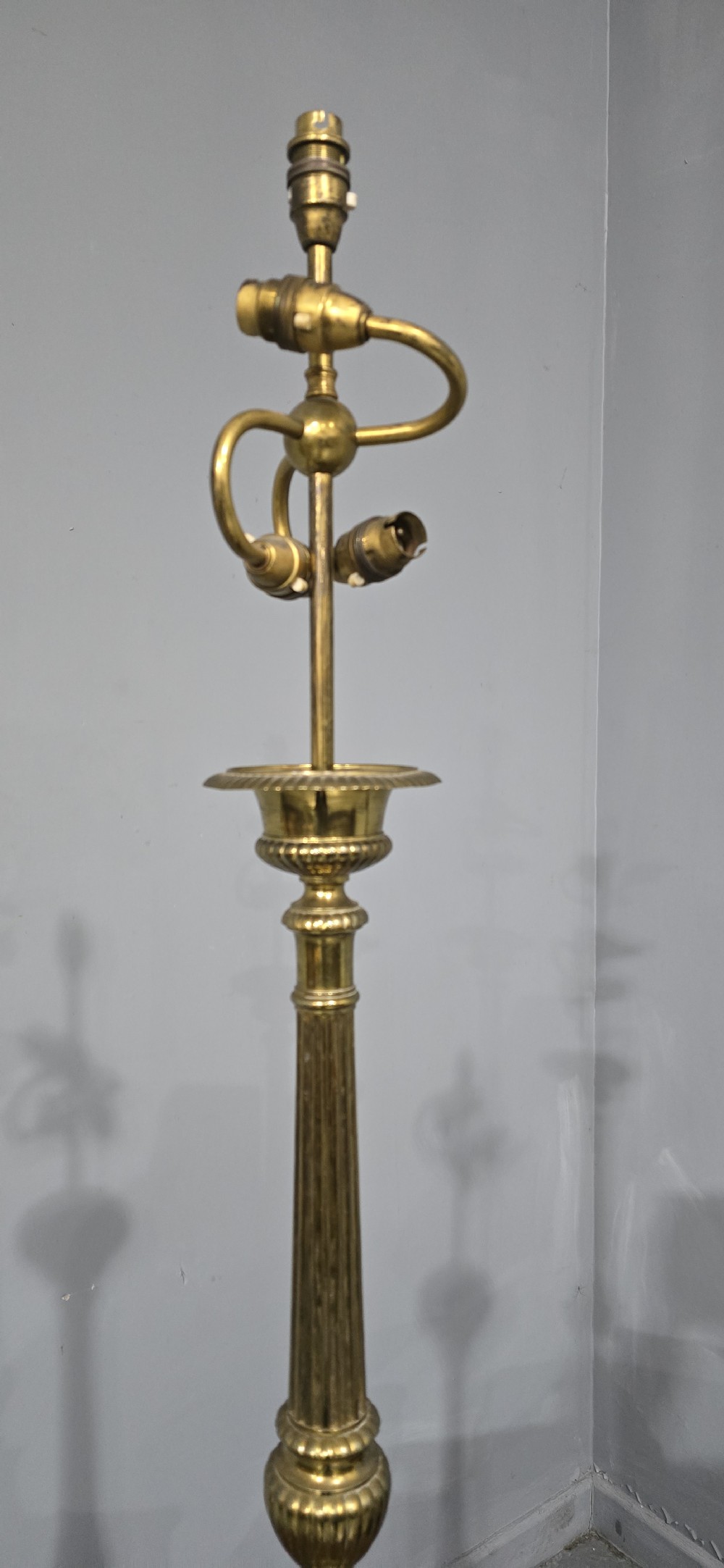 A pair of tall cast brass candlestick table lamps featuring fluted columns, relief portrait medallions on triform bases, and multi-bulb electrical fittings at the top. View III
