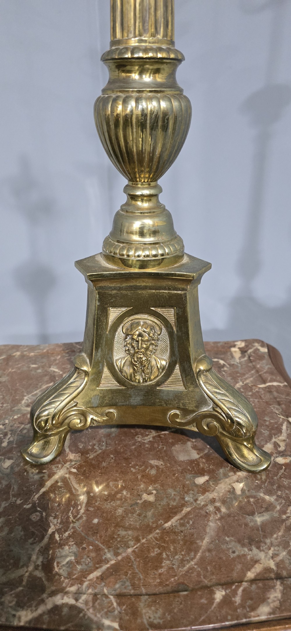 A pair of tall cast brass candlestick table lamps featuring fluted columns, relief portrait medallions on triform bases, and multi-bulb electrical fittings at the top. View VI
