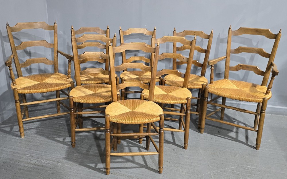 A set of eight French country wooden dining chairs featuring wavy ladderback rails and natural woven rush seats. View II