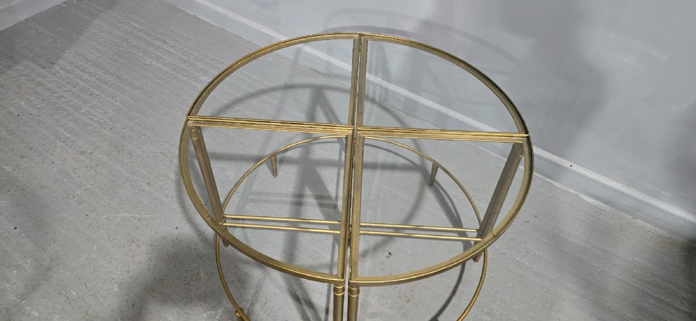 A set of four quadrant-shaped gold brass tables with glass tops arranged together to form a single circular surface. View II