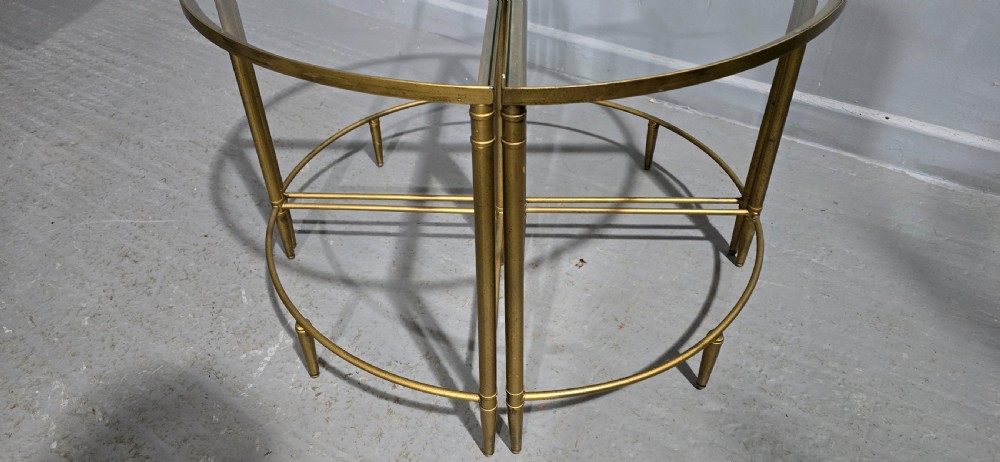 A set of four quadrant-shaped gold brass tables with glass tops arranged together to form a single circular surface. View III