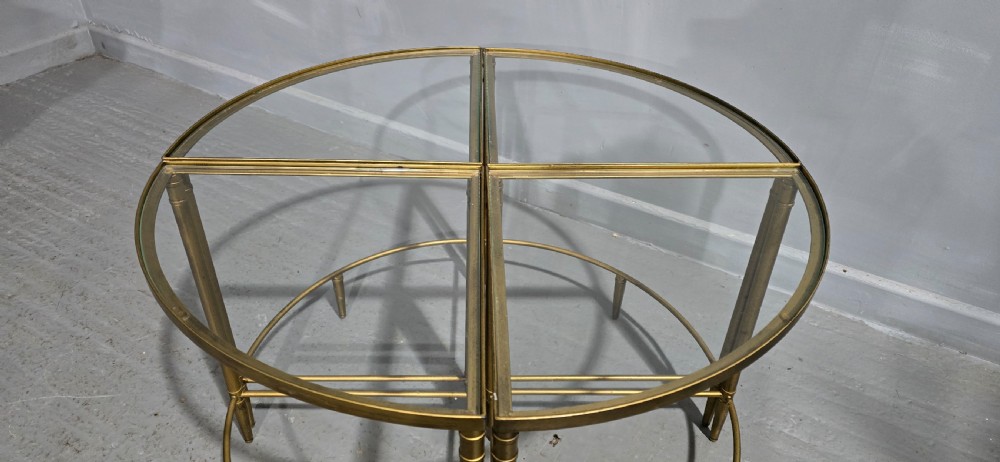 A set of four quadrant-shaped gold brass tables with glass tops arranged together to form a single circular surface. View VII