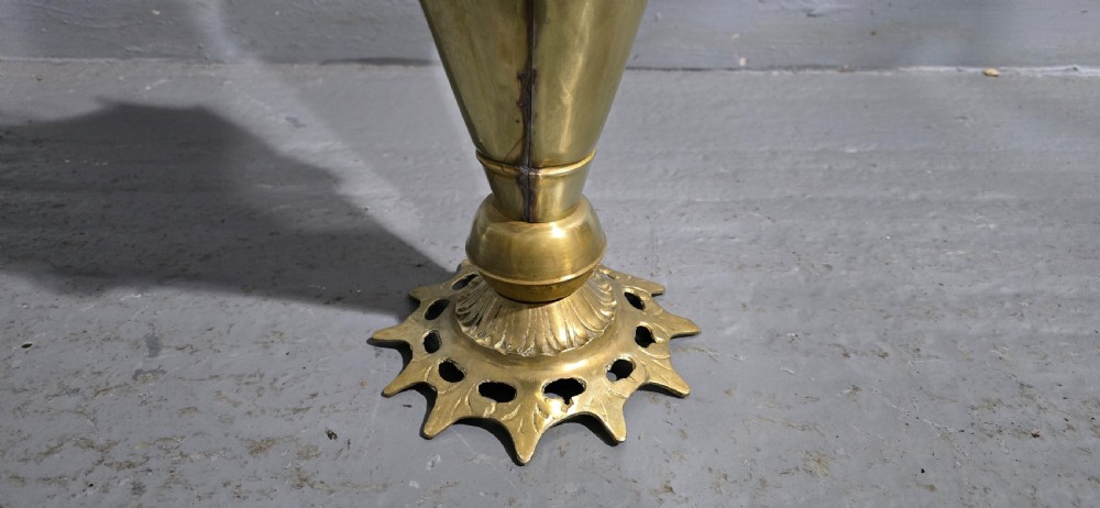 An antique umbrella-shaped brass umbrella stand featuring relief mascaron face details and a central curved hook handle. View IV