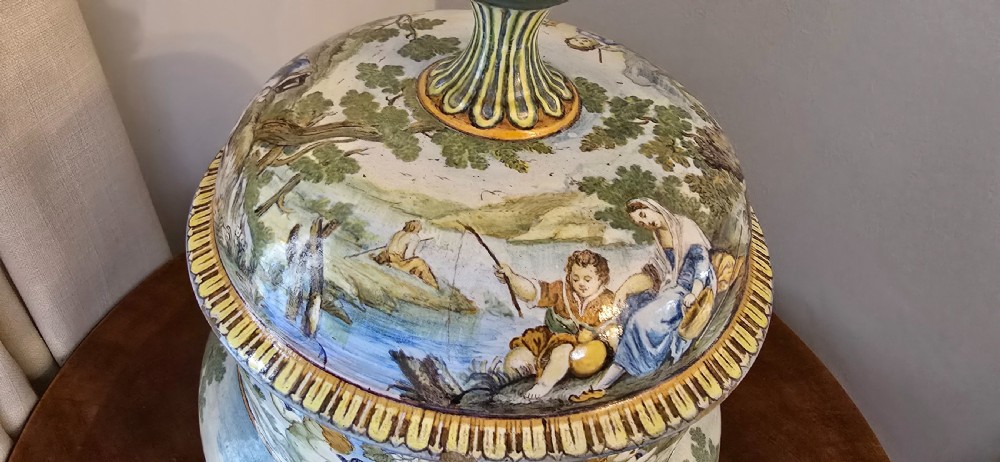 An 18th-century Italian tin-glazed earthenware lidded jar decorated with painted classical landscapes, cherubs, and architectural ruins. View III