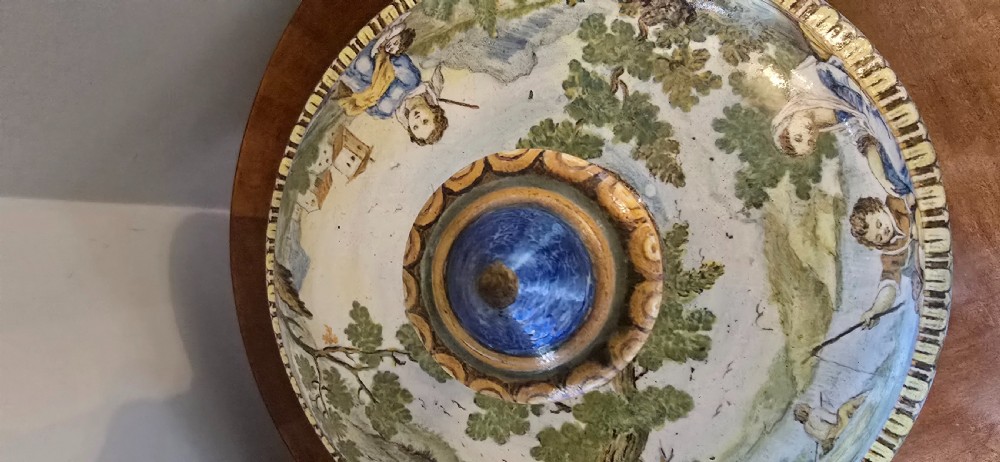An 18th-century Italian tin-glazed earthenware lidded jar decorated with painted classical landscapes, cherubs, and architectural ruins. View V