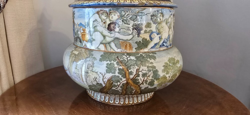 An 18th-century Italian tin-glazed earthenware lidded jar decorated with painted classical landscapes, cherubs, and architectural ruins. View VI