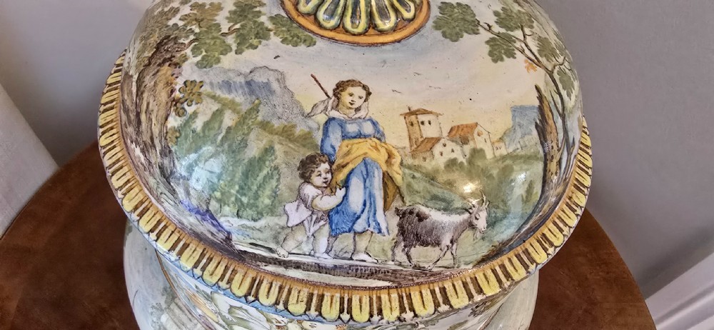 An 18th-century Italian tin-glazed earthenware lidded jar decorated with painted classical landscapes, cherubs, and architectural ruins. View VII