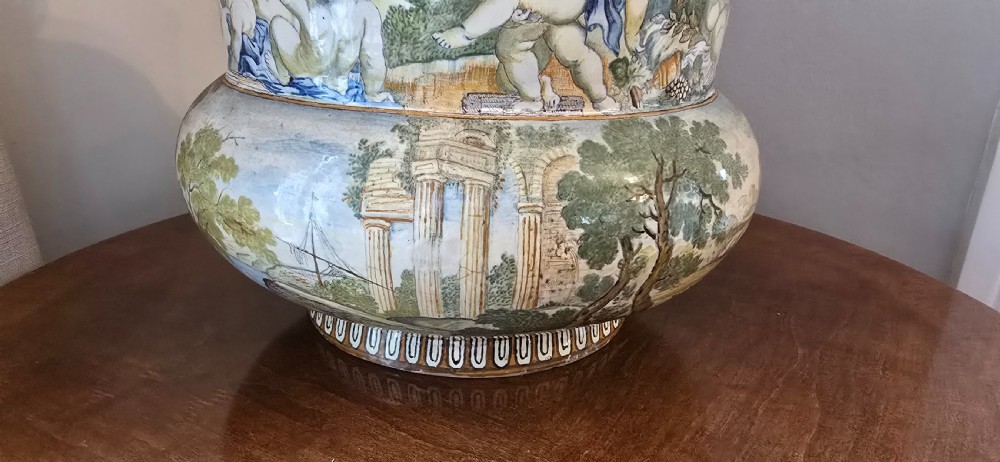 An 18th-century Italian tin-glazed earthenware lidded jar decorated with painted classical landscapes, cherubs, and architectural ruins. View IX