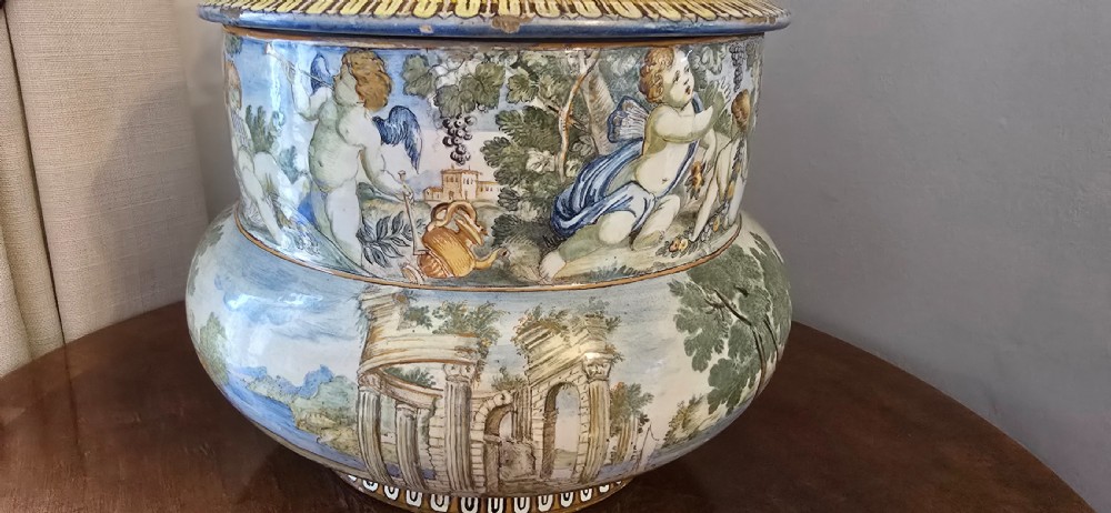 An 18th-century Italian tin-glazed earthenware lidded jar decorated with painted classical landscapes, cherubs, and architectural ruins. View XIII